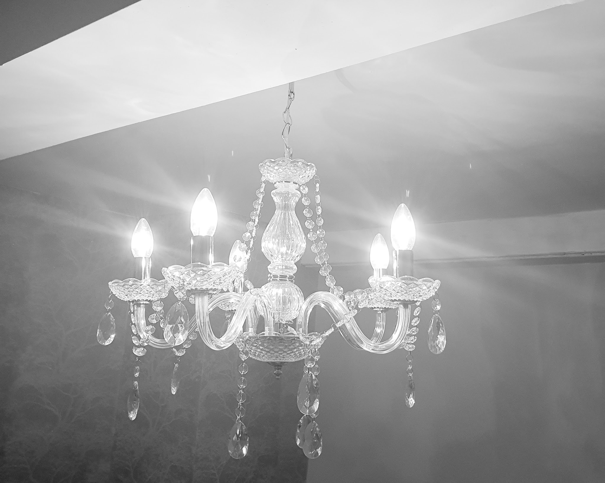 A crystal chandelier with candle bulbs, in black and white